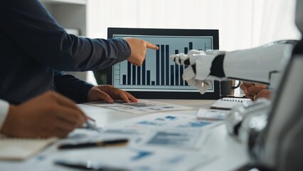 Poster - A business team collaborates in a modern office setting, analyzing data presented on a screen, with a focus on trends and strategic planning aided by robotic technology.Noogenesis