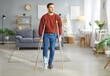 © Studio Romantic - Broken leg or foot injury man walking on crutches with bandaged leg at home, patient on rehabilitation period, painful swollen foot, not be able to walk after severe fracture, protective cover
