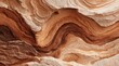 © Glint - Abstract close-up of layered, sedimentary rock formation showcasing swirling, undulating patterns in warm, earthy tones of brown, beige, and tan.