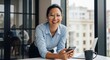 © Vectarica - Smiling businesswoman with phone in modern office: stock photo of professional woman at work with laptop and coffee, corporate image for success and leadership