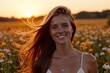 © Vera - Windswept Beauty: A woman with long hair standing in a field of wildflowers at sunset