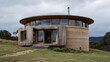 © Designs to Display - A hilltop circular home made from rammed earth reclaimed timber captured in overcast lighting for soft shadow gradients