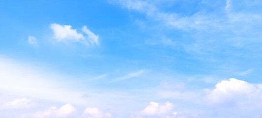 Wall Mural - A stunning background of a clear blue sky with delicate white cloud formations on a bright sunny day. Peaceful and serene atmosphere, suitable for themes related to nature, weather, relaxation, travel