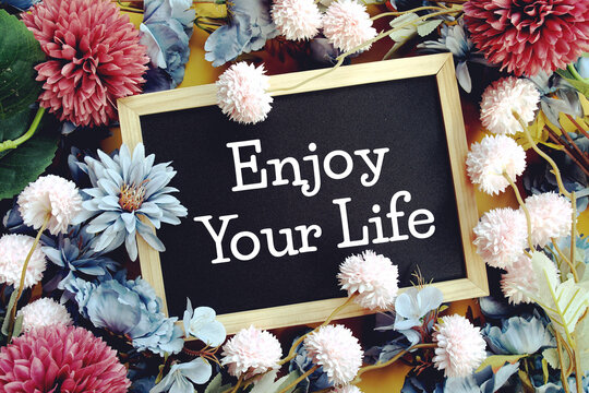 Enjoy Your Lifey text with flowers decoration on yellow background