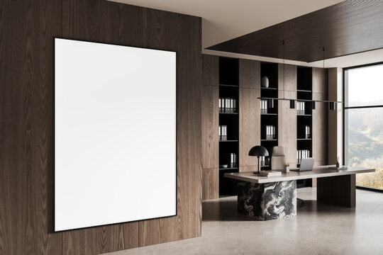Blank poster mockup on wooden wall in modern office interior with minimalist furniture and open shelves near large window in daylight setting. 3D Rendering