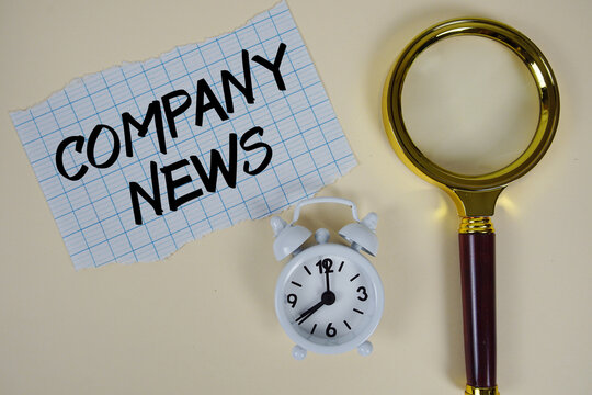 Company News text written on paper with magnifying glass and alarm clock