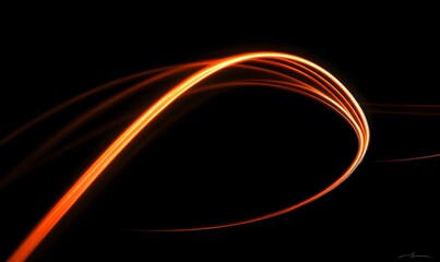 Poster - Dynamic Orange Light Trail Against a Dark Background