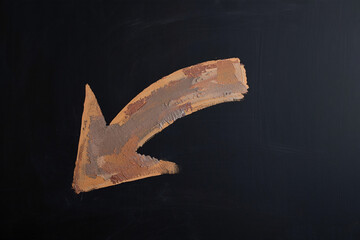 Poster - A painted brown arrow pointing down and to the left on a black background art
