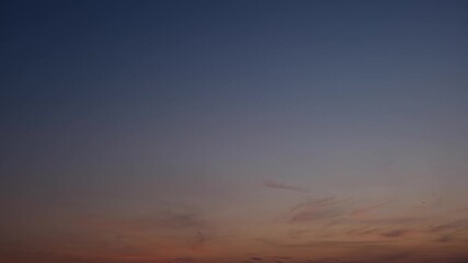 Wall Mural - a sunrise timelapse video reveals a serene sky transitioning from deep blue to soft golden hues as t