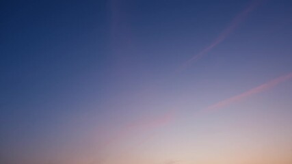 Wall Mural - a peaceful sunset sky timelapse with soft pink clouds streaking across a deepening blue and purple h