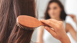 Young woman combing his hair in the bathroom