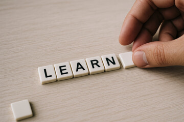 Poster - A carefully arranges white tiles forming a clear message that symbolizes the gradual process acquiring knowledge and development in a professional setting