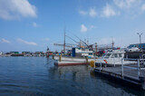 Fishing boats moored at a peaceful harbor under a clear summer sky