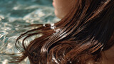 Wet brown hair flowing in clear water with sunlight reflecting, creating calm and refreshing atmosphere