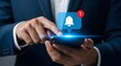 © Yassine - Person in a suit using a smartphone with a notification bell icon and a red circle with the number one