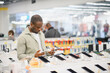 © Serhii - Customer comparing smartphones in electronics store