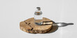 © khan - Clear liquid in glass bottle on a rustic wooden slice with dramatic lighting
