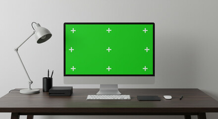 Fototapete - Computer with green screen on a desk with lamp keyboard mouse and other accessories on a dark wooden table