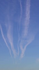Wall Mural - Airplane contrail against blue sky with white cloud. Jet plane condensation trail. Clouds lines made of aircraft