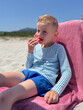 © Elena - Child Enjoying Watermelon on Beach Chair in the Sun