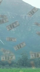 Poster - Falling dollar bills animation over wind turbines in mountainous landscape