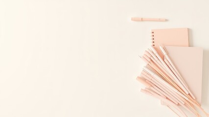 Poster - Minimalist arrangement of pale pink pens, spiral notebook and notepad on a light cream background, a simple and pleasing still life