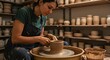 © Bayueka - Concentrated artisan shapes clay on a wheel, crafting pottery with skilled hands in her ceramic workshop surrounded by finished pieces.