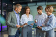 © ty - Group of business people standing together and discussing their work and projects, having a team meeting in an office.