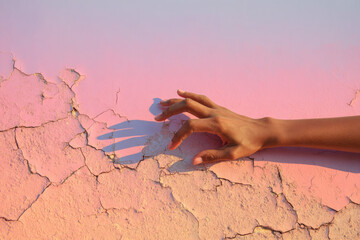 Aufkleber - Hand gently touches cracked pastel wall, creating soft and emotional scene with warm light and delicate shadow, highlighting texture and subtle color gradient