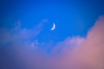 Wall Mural - There is a white crescent moon and red clouds in the dark(deep) blue sky.