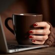 © BrandwayArt - Woman holding mug near laptop on wooden desk in the afternoon