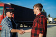 © phoenix021 - Truck driver shaking hands with fleet manager in front of the truck