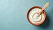 © Pete - Top view creamy yogurt clay bowl with wooden spoon. Rustic, natural, organic food photo. Healthy breakfast snack. Dairy product with probiotics, good for guts health. Nutrition concept.