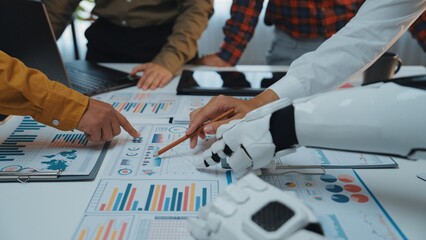 Poster - A dynamic scene of human and robotic collaboration in the workplace, showcasing data analysis through graphs and charts, emphasizing innovation and teamwork.Noogenesis