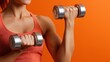 © OleksandrZastrozhnov - Young caucasian female exercising with dumbbells against orange background