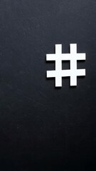 Poster - A minimalist image of a white hashtag symbol placed on a textured dark gray background viewed from directly above