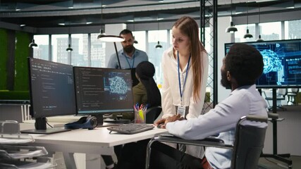 Poster - Young engineer and coworker with paraplegia doing brainstorming in office, reviewing AI system metrics. Junior dev and colleague in wheelchair talking, tuning neural networks using PC, camera A