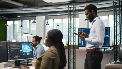 Fototapete - Joyous technician in office automating repetitive tasks using AI scripts. Upbeat man in workplace using artificial intelligence to speed up feature implementation, camera A
