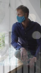 Poster - Animation of financial graphs over caucasian man in face mask sitting at window