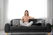 © Pixel-Shot - Beautiful young woman meditating on sofa at home