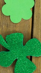 Poster - Animation of multiple clover leaves on wooden background