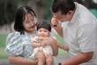 © phaitoon - Joyful Family Moments Captured with Baby in a Natural Setting