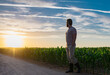 © Volodymyr - A farmer inspects the cornfield on sunset. The male farmer works outdoors in the field. Agricultural worker farmer harvesting corn. A man examines the maize crop. Farmers work to harvest the crop.