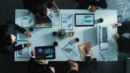 Poster - Top down aerial view of skilled businessman pointing financial chart at whiteboard while smart investor listening presentation and analyze stock market investment graph at meeting table. Directorate.