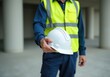 © Evgeny - Construction worker holding white hard hat promoting safety on site