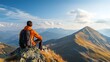 © phetsavun - A hiker in an orange jacket sits on a mountain peak, overlooking a scenic landscape of mountains under a blue sky with clouds.