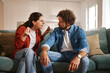 © Stockphotodirectors - A woman passionately argues with a man on a sofa while he listens attentively. Tension fills the air as they discuss their relationship issues in a cozy living room.