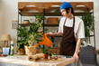 © Bliss - Handsome young man diligently transplanting vibrant plants in a cozy studio environment
