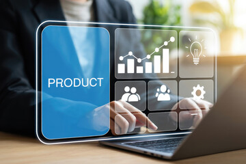 A person is typing on a laptop with a digital interface displaying product icons on a wooden desk in a bright office