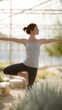 © t.sableaux - A teen practicing yoga in a serene greenhouse, balancing gracefully on one leg amidst lush greenery and natural light, promoting wellness and tranquility